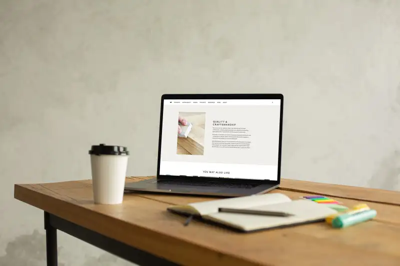 mockuuups macbook pro mockup on a table beside a cup of coffee