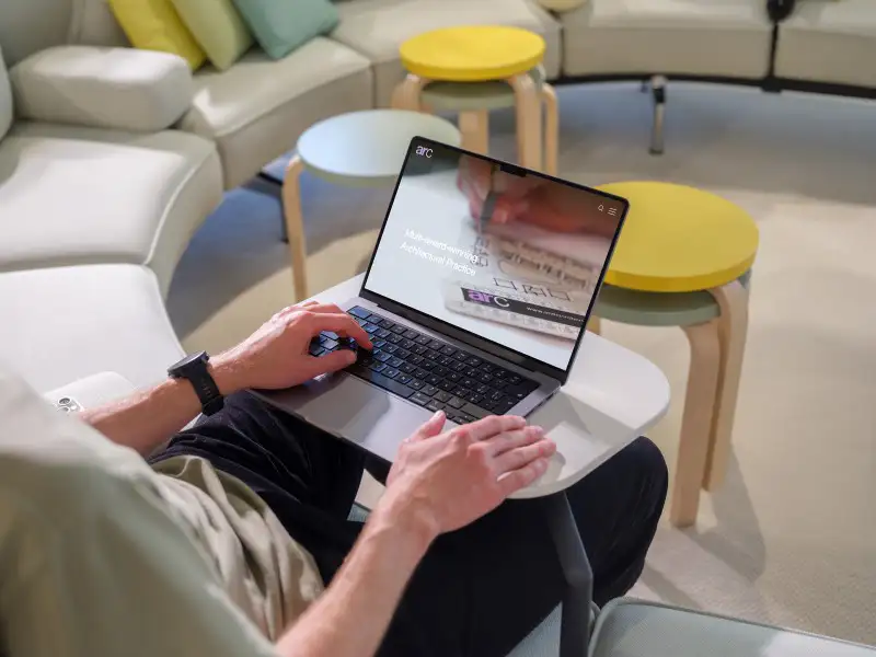 mockuuups macbook pro mockup with a man in a casual workspace