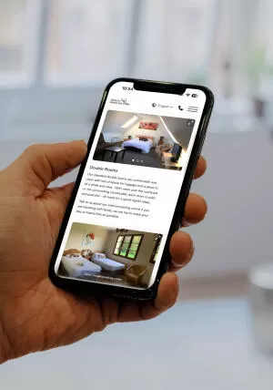 mockuuups holding iphone 12 pro mockup in front of windows