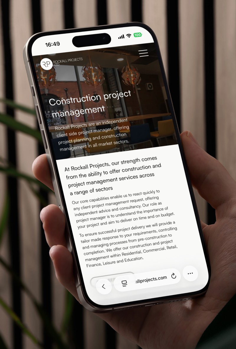 mockuuups iphone 15 pro mockup in a male hand against a modern backdrop