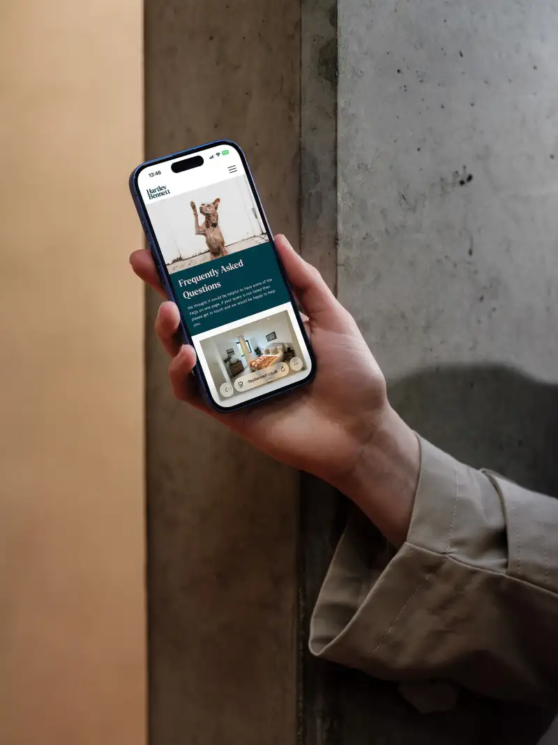 mockuuups iphone 16 mockup held against a concrete wall
