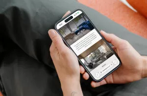 mockuuups iphone 15 pro mockup in a womans hand on a cozy couch