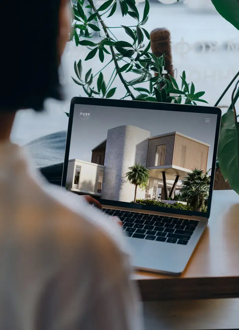 mockuuups macbook mockup in front of a user with plants in the background