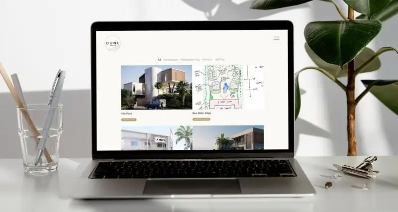 mockuuups macbook mockup on a white table with hard root plant at the side